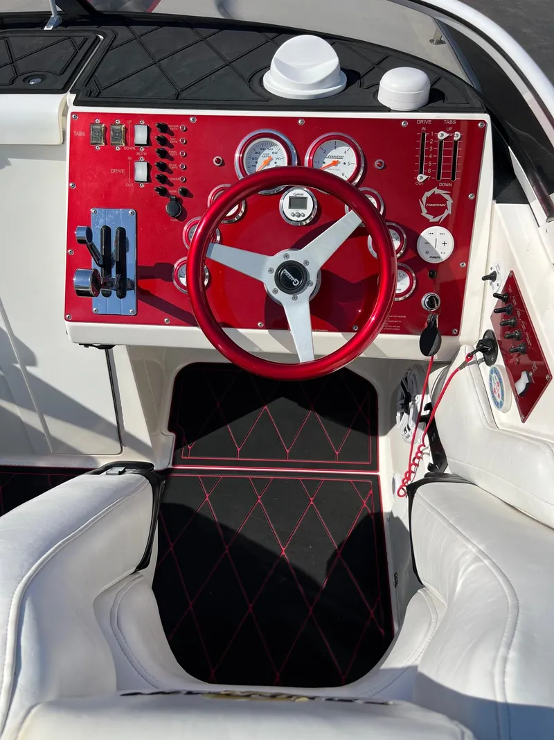Slide: The Image of 2004 Fountain 29 Fever boat cockpit with red dashboard and steering wheel. - 12