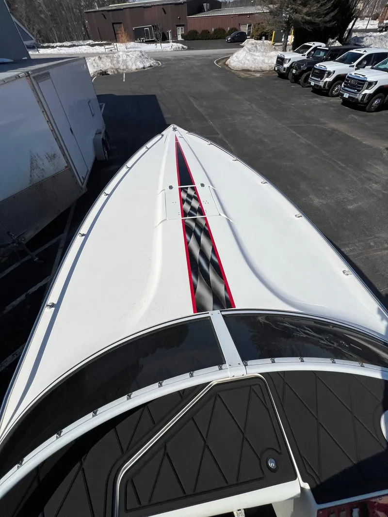 Slide: The Image of 2004 Fountain 29 Fever boat with sleek design and red accents, parked outdoors. - 18