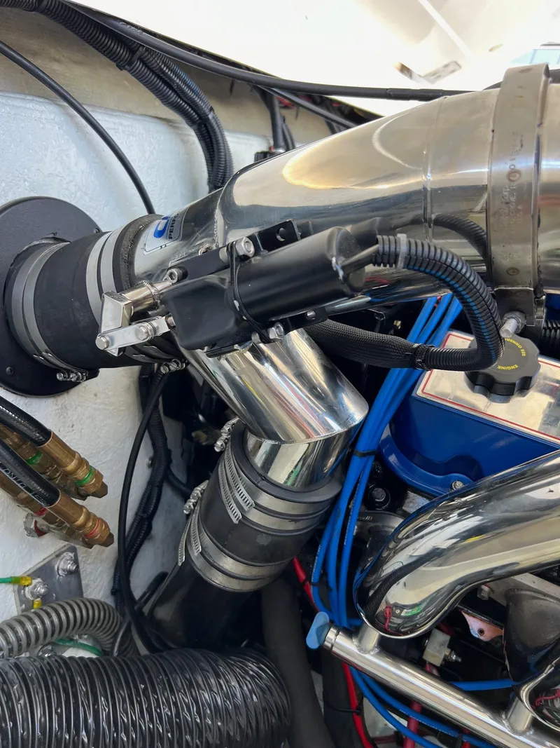 Slide: The Image of Engine components of a 2004 Fountain 29 Fever boat, featuring metallic pipes and wiring. - 20