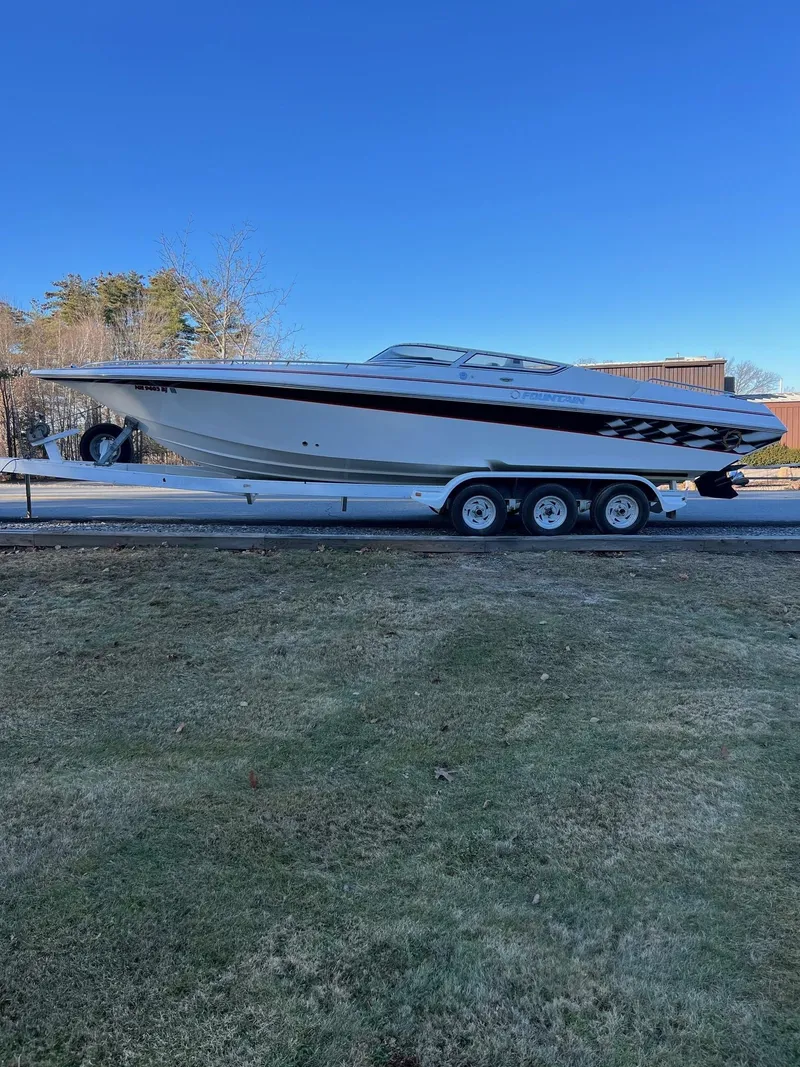 Slide: The Image of 2004 Fountain 29 Fever speedboat on trailer, parked outdoors under clear blue sky. - 5