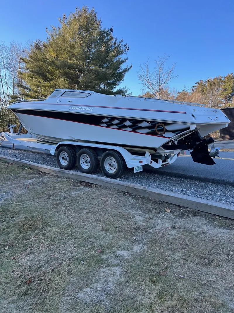 Slide: The Image of 2004 Fountain 29 Fever boat on a trailer, parked outdoors with trees in the background. - 7