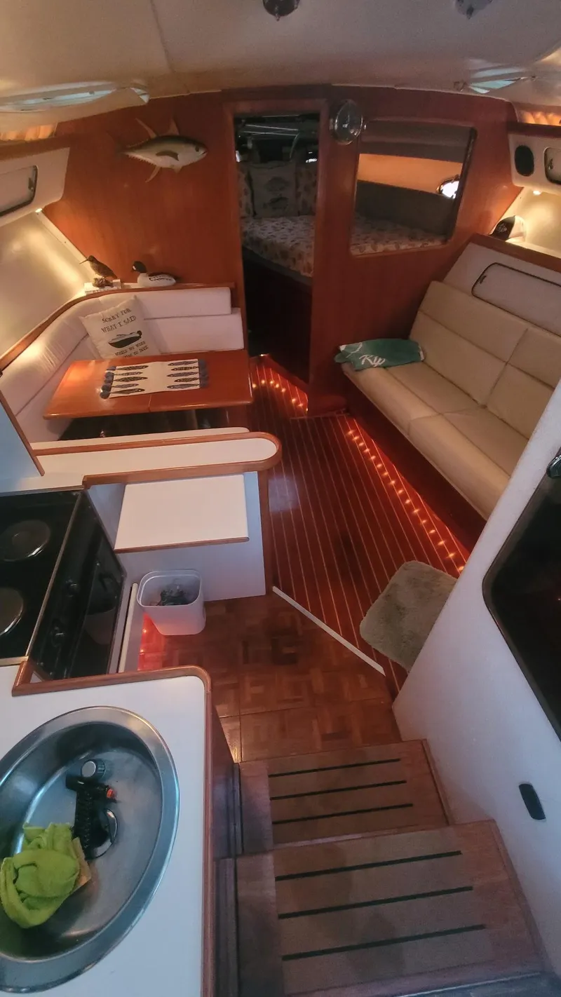 Slide: The Image of Interior of a 1992 Tiara Yachts 36 Open, featuring cozy seating and a compact kitchen area. - 10