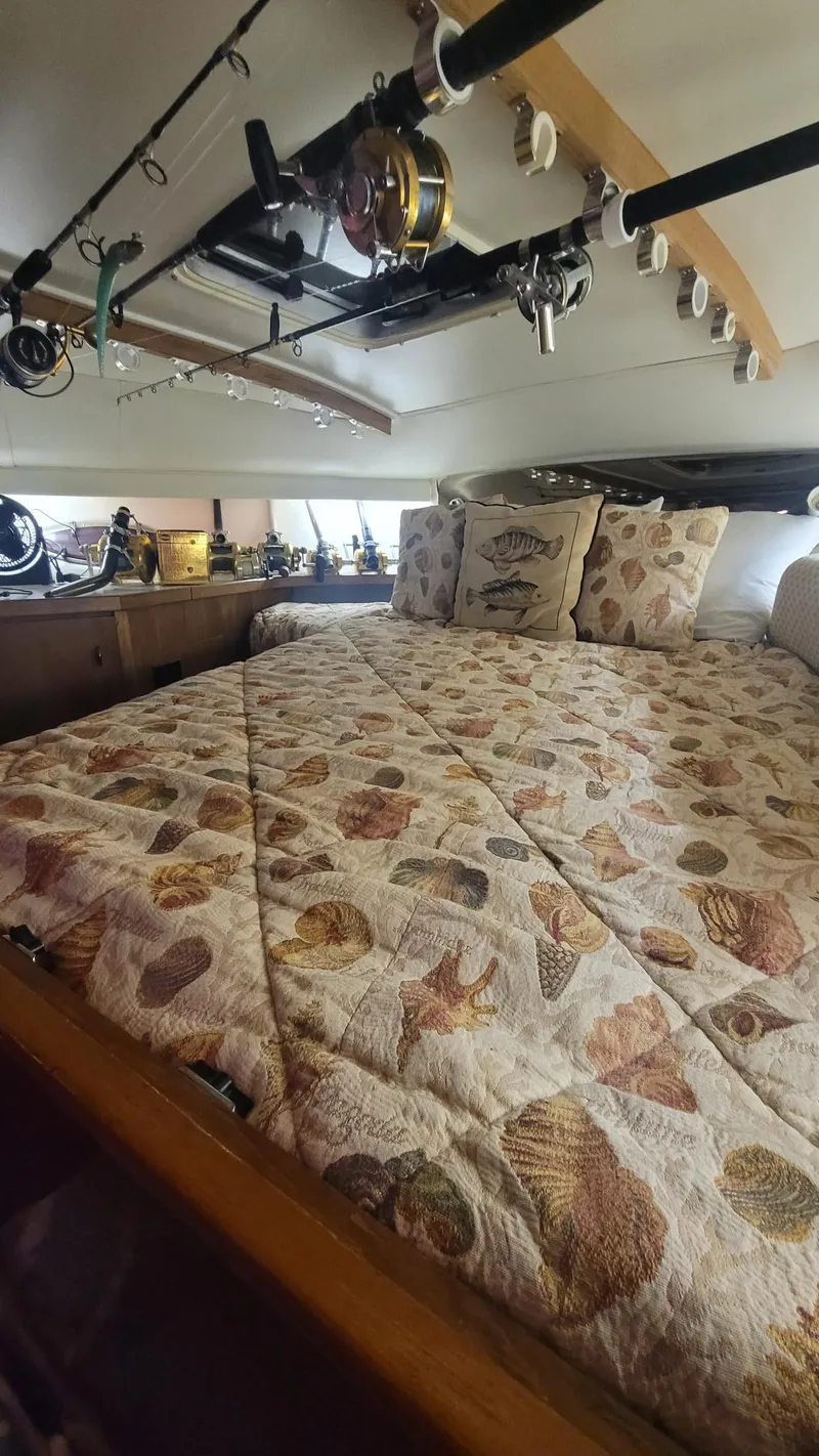 Slide: The Image of Cozy cabin interior of 1992 Tiara Yachts 36 Open with fishing rods and seashell-themed bedding. - 12