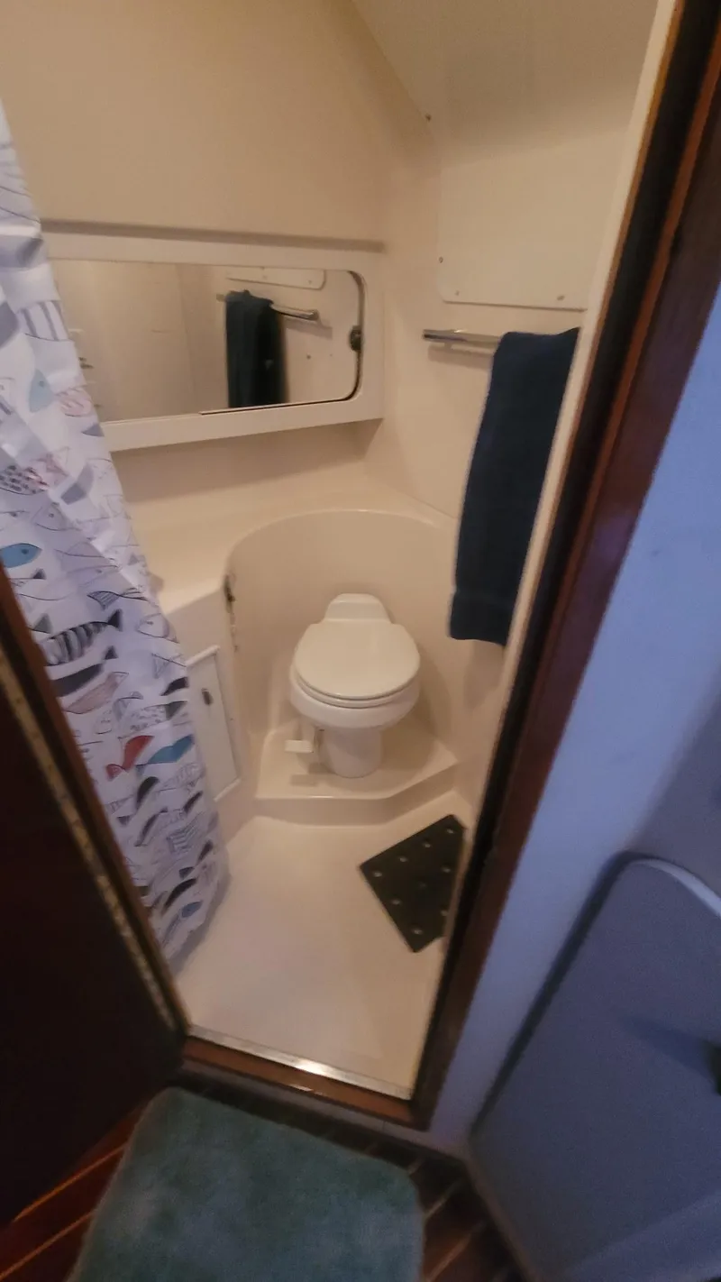 Slide: The Image of Bathroom interior of 1992 Tiara Yachts 36 Open, featuring a compact toilet and shower. - 13