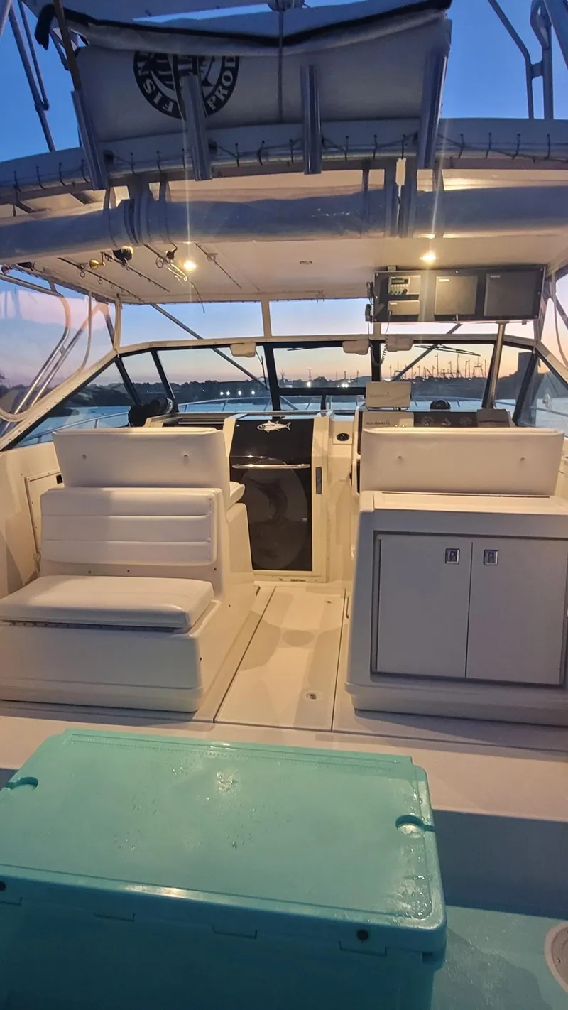 Slide: The Image of 1992 Tiara Yachts 36 Open interior with seating and storage, docked at sunset. - 4