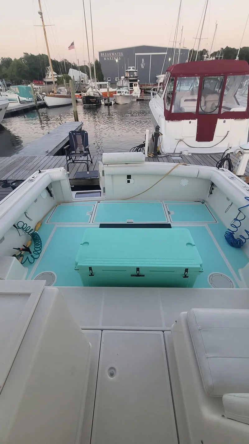 Slide: The Image of 1992 Tiara Yachts 36 Open at marina, featuring spacious deck and turquoise storage box. - 7