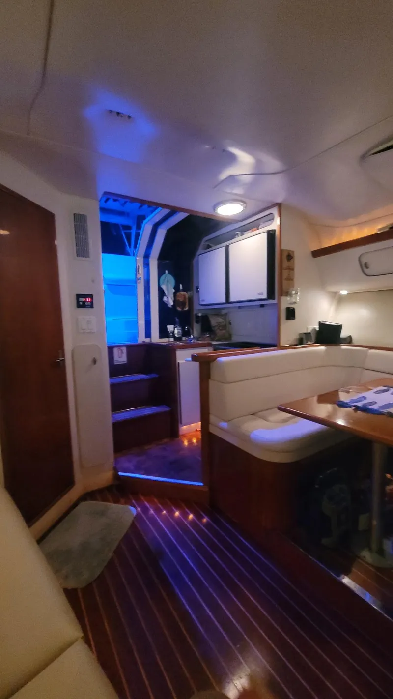 Slide: The Image of Interior of 1992 Tiara Yachts 36 Open, featuring cozy seating and ambient lighting. - 9