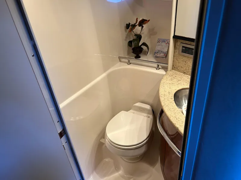 Slide: The Image of Compact bathroom in a 2004 Sea Ray 420 Sundancer yacht, featuring a toilet and sink. - 15