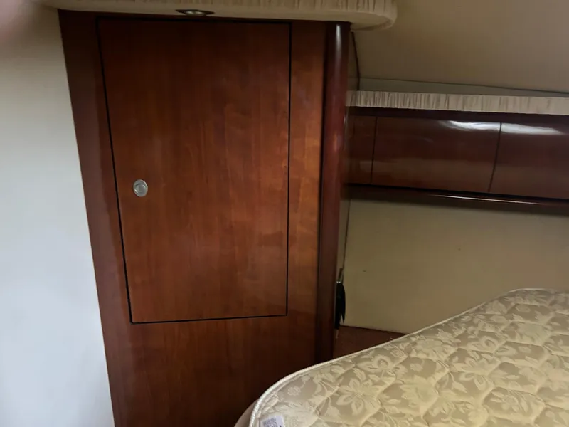 Slide: The Image of Interior cabin of 2004 Sea Ray 420 Sundancer with wooden cabinetry and bed. - 16