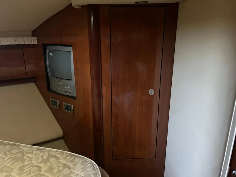 Slide: The Image of 2004 Sea Ray 420 Sundancer cabin interior with TV and wooden cabinetry. - 17