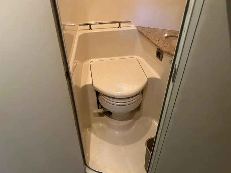 Slide: The Image of 2004 Sea Ray 420 Sundancer bathroom with compact toilet and countertop. - 21