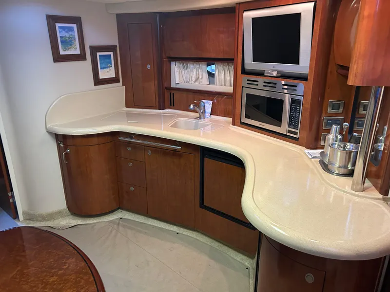 Slide: The Image of 2004 Sea Ray 420 Sundancer yacht interior with modern kitchen and entertainment system. - 23
