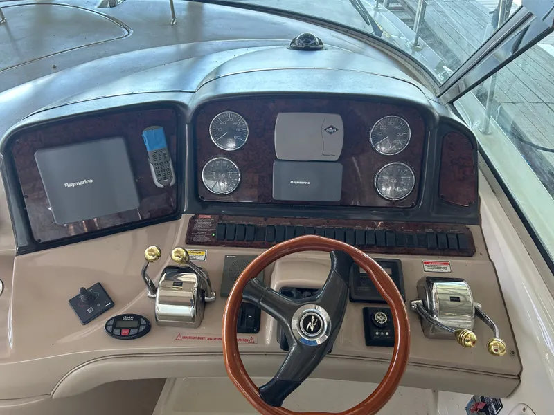 Slide: The Image of 2004 Sea Ray 420 Sundancer helm with steering wheel and navigation controls. - 25