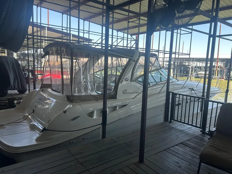 Slide: The Image of 2004 Sea Ray 420 Sundancer docked in a covered marina. - 34