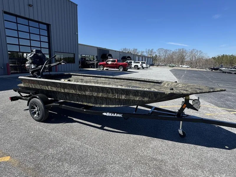 The Image of 2025 SeaArk 1752 Slayer Pro boat on trailer, parked outside dealership. - 1