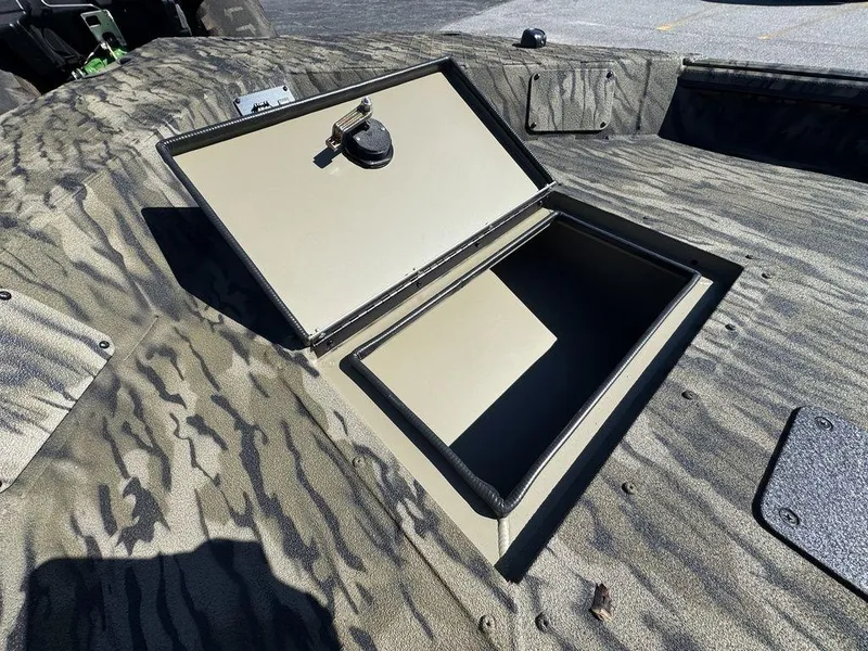 Slide: The Image of 2025 SeaArk 1752 Slayer Pro boat with open storage compartment, camo design. - 13