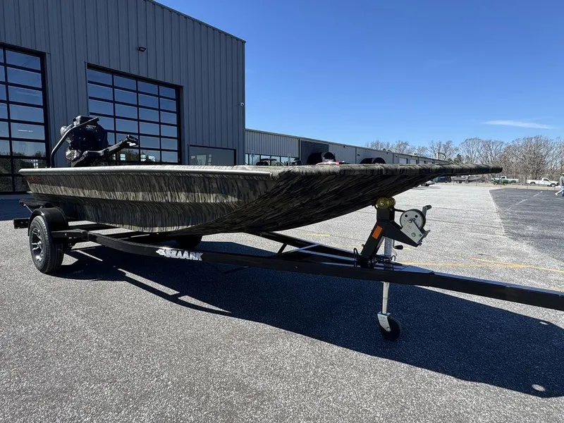 Slide: The Image of 2025 SeaArk 1752 Slayer Pro boat on trailer, parked outside industrial building. - 3