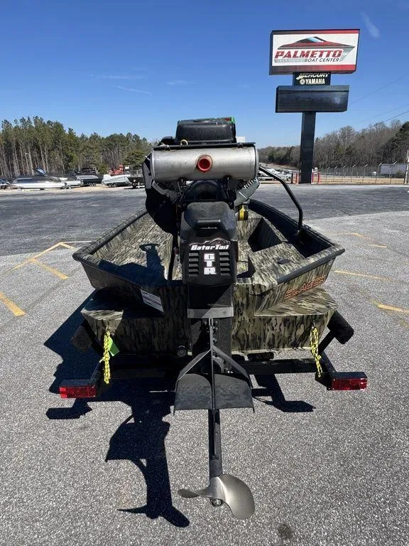 Slide: The Image of 2025 SeaArk 1752 Slayer Pro boat with motor, parked outdoors near dealership. - 6
