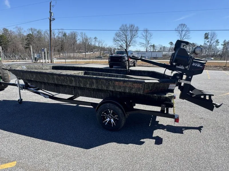 Slide: The Image of 2025 SeaArk 1752 Slayer Pro boat on trailer in parking lot, side view. - 8