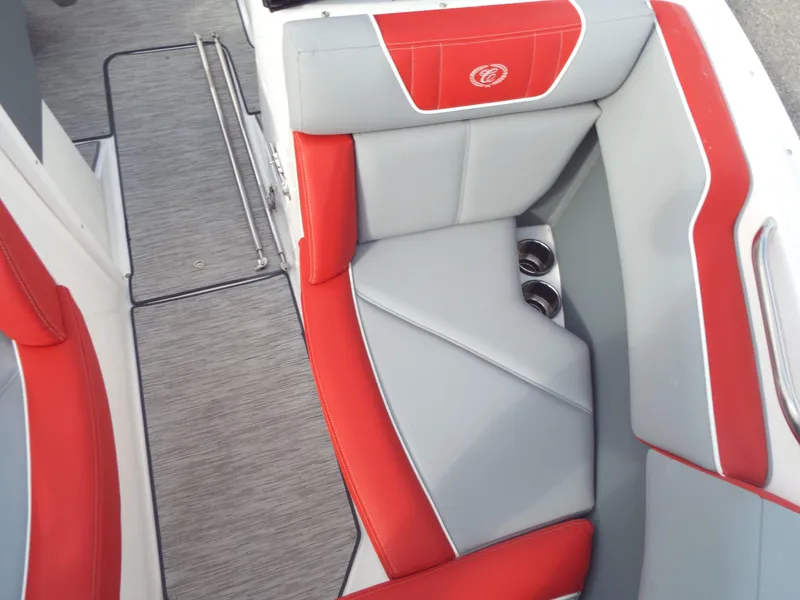 Slide: The Image of 2021 Cobalt CS22 boat interior with red and gray seating, cup holders, and textured flooring. - 4