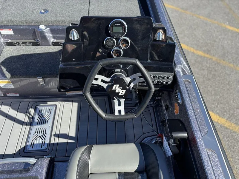 Slide: The Image of 2025 Bass Cat Puma STS boat dashboard with steering wheel and control panel. - 11
