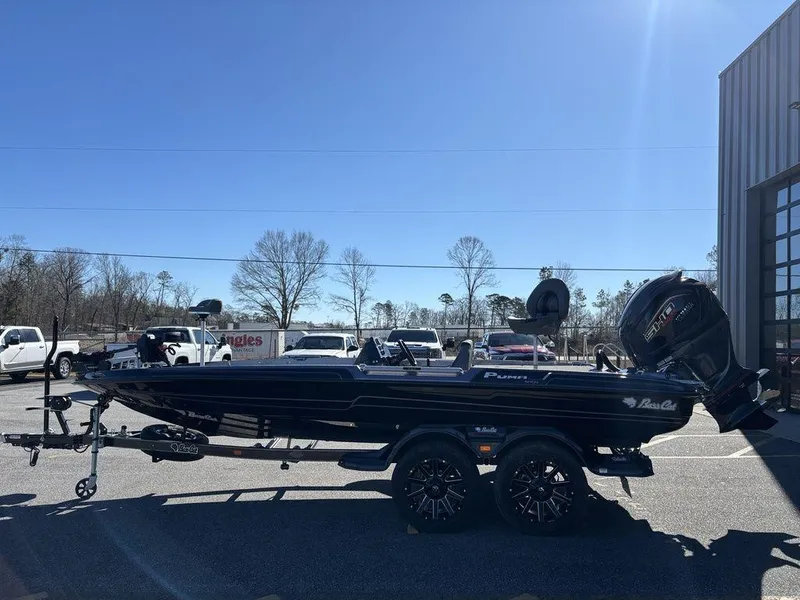 Slide: The Image of 2025 Bass Cat Puma STS boat on trailer, parked outdoors under clear sky. - 5