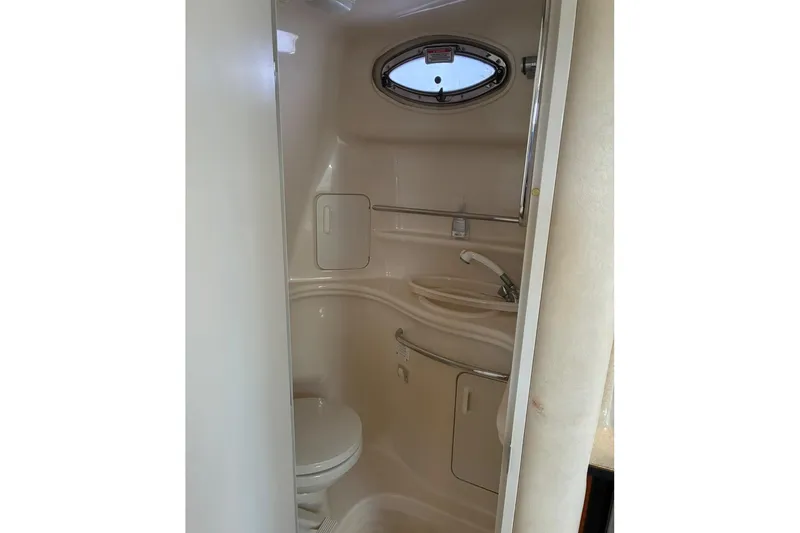 Slide: The Image of 2002 Sea Ray 340 Sundancer bathroom with compact design and oval window. - 11
