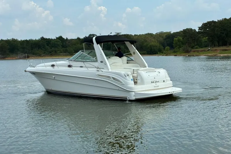 Slide: The Image of 2002 Sea Ray 340 Sundancer cruising on a calm lake with wooded shoreline. - 14