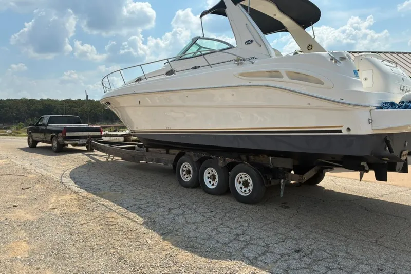 Slide: The Image of 2002 Sea Ray 340 Sundancer boat on trailer, towed by a black truck. - 21