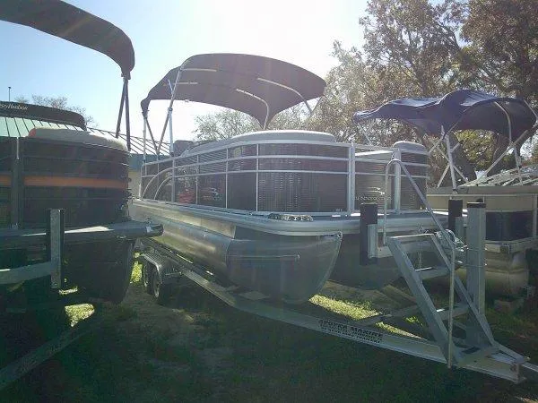 Slide: The Image of 2023 Bennington 208SLJ Tri-toon boat on trailer, parked outdoors under canopy. - 10