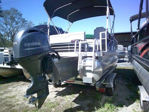 Slide: The Image of 2023 Bennington 208SLJ Tri-toon with Yamaha outboard motor, parked on a trailer. - 8