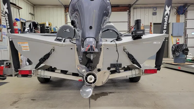 Slide: The Image of 2023 Xpress H18C Crappie boat with Yamaha Vmax 115 SHO engine in a garage. - 11