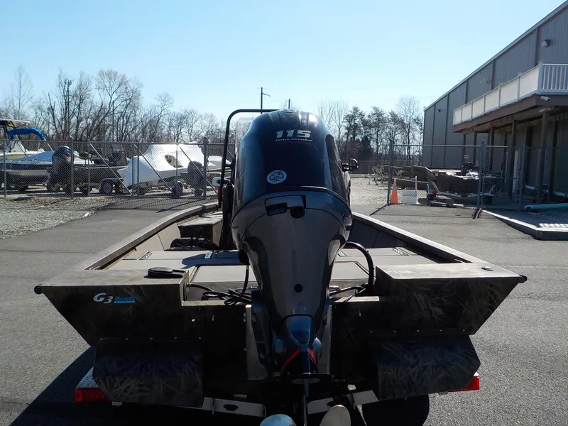 Slide: The Image of 2019 G3 Bay 20 DLX Camo boat with 115 HP outboard motor in a storage yard. - 17
