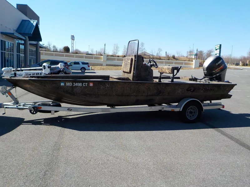 Slide: The Image of 2019 G3 Bay 20 DLX Camo boat on trailer in parking lot. - 6