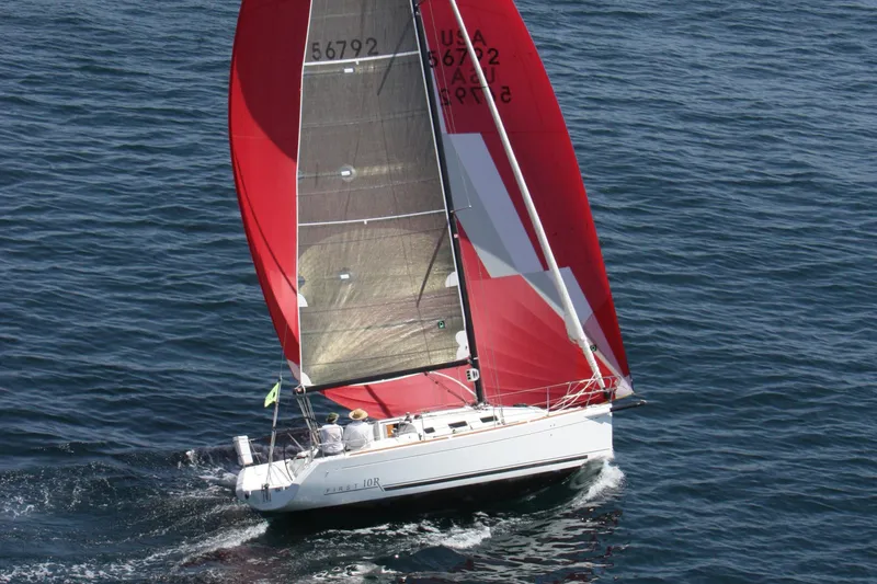 Slide: The Image of Sailing yacht Beneteau First 10R 2007 with red sails on open water. - 0