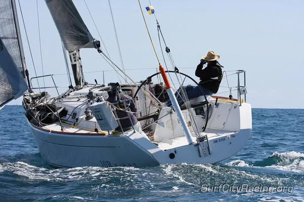 Slide: The Image of 2007 Beneteau First 10R sailboat navigating ocean waves with a sailor onboard. - 1