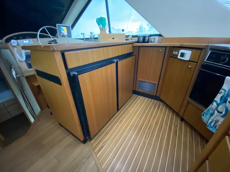 Slide: The Image of Interior of 2001 Bayliner 3988 yacht with wooden cabinetry and modern appliances. - 15