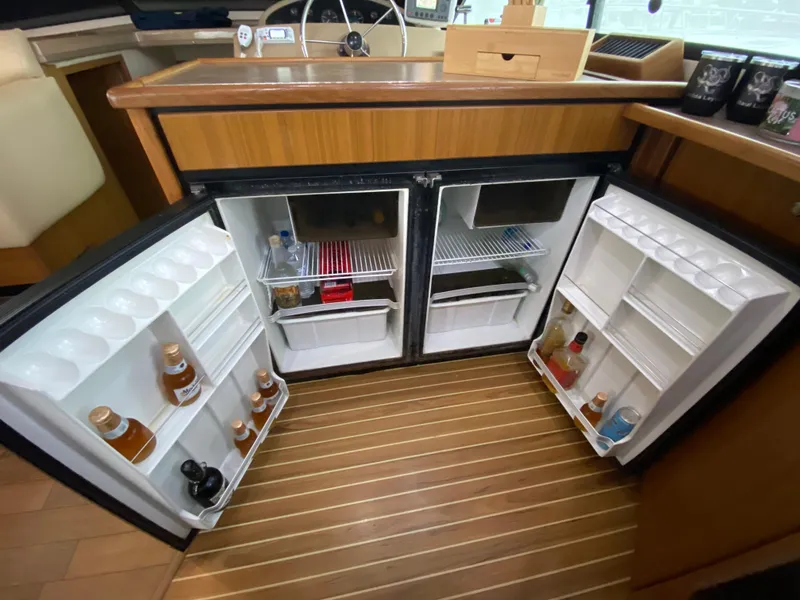 Slide: The Image of 2001 Bayliner 3988 yacht kitchen with open dual refrigerators, showcasing organized storage. - 16