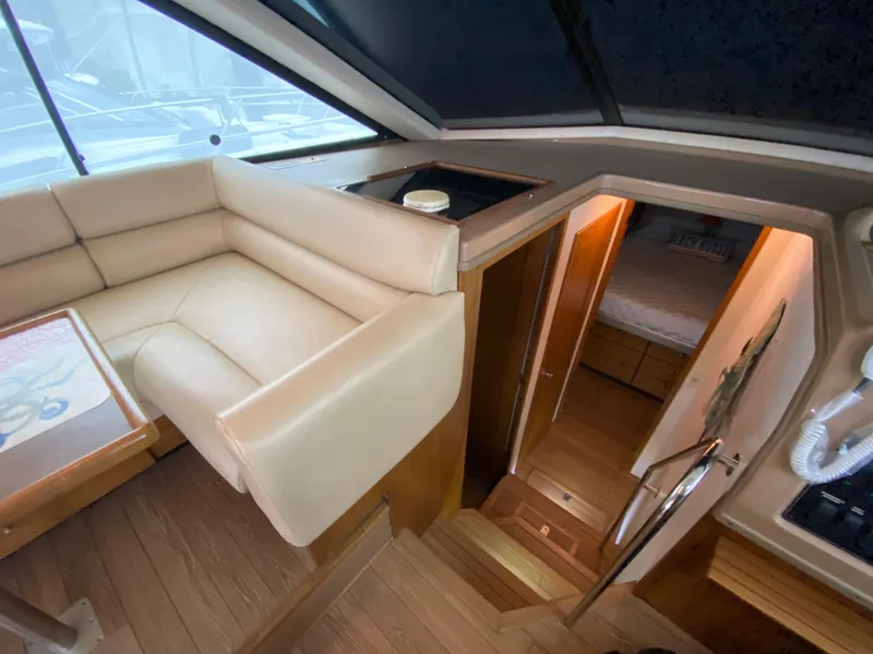 Slide: The Image of Interior of 2001 Bayliner 3988 yacht, featuring a cozy seating area and cabin entrance. - 19
