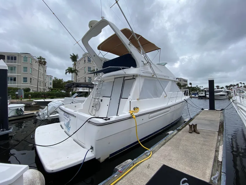 Slide: The Image of 2001 Bayliner 3988 yacht docked at marina under cloudy skies. - 2