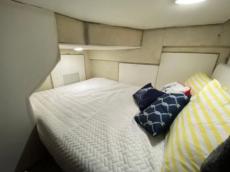 Slide: The Image of 2001 Bayliner 3988 cabin interior with cozy bed and decorative pillows. - 23