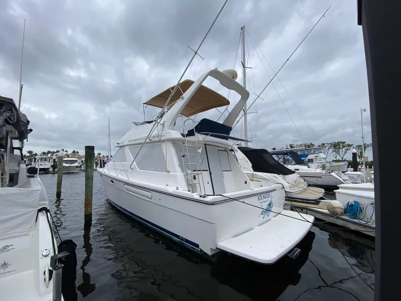 Slide: The Image of 2001 Bayliner 3988 yacht docked at marina under cloudy skies. - 3