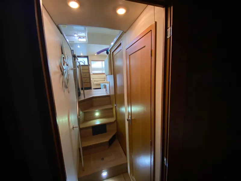 Slide: The Image of Interior view of 2001 Bayliner 3988 yacht, featuring wooden stairs and cozy lighting. - 31