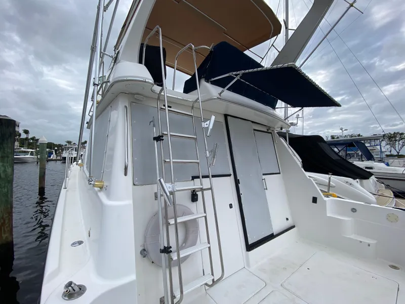 Slide: The Image of 2001 Bayliner 3988 yacht with ladder and canopy, docked at marina. - 42