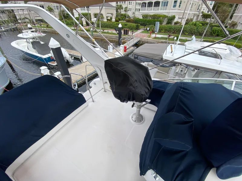 Slide: The Image of 2001 Bayliner 3988 yacht deck with covered seating and marina view. - 47