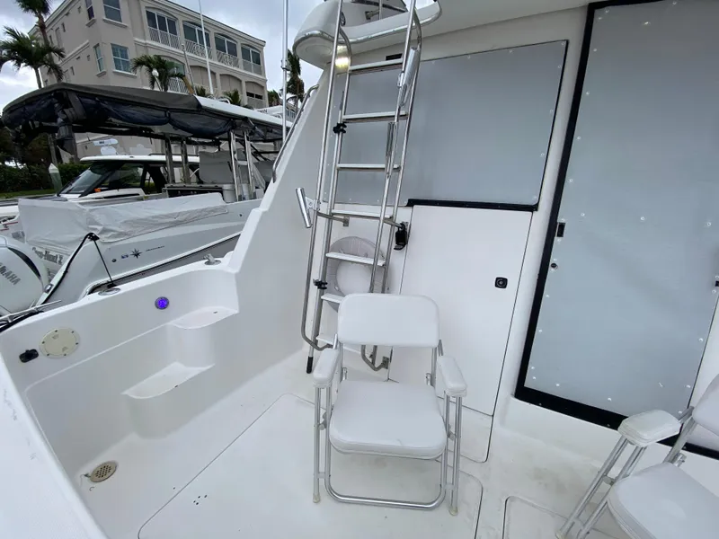 Slide: The Image of 2001 Bayliner 3988 yacht deck with seating and ladder, docked at marina. - 6