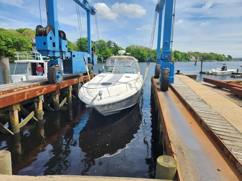The Image of 2003 Sea Ray 340 Sundancer boat being lifted at a marina dock. - 0