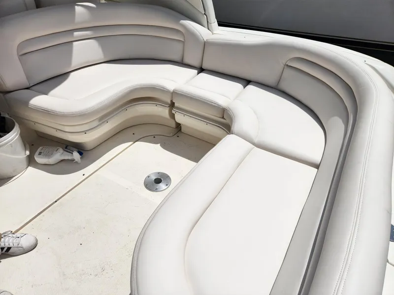Slide: The Image of 2003 Sea Ray 340 Sundancer boat interior with white cushioned seating. - 11