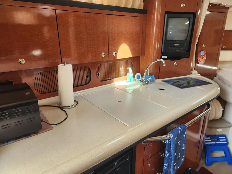 Slide: The Image of 2003 Sea Ray 340 Sundancer interior kitchen with wooden cabinets and modern appliances. - 19