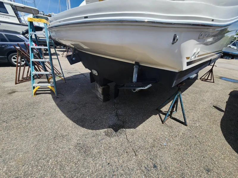 Slide: The Image of 2003 Sea Ray 340 Sundancer boat on stands, with ladder nearby, in a marina setting. - 4